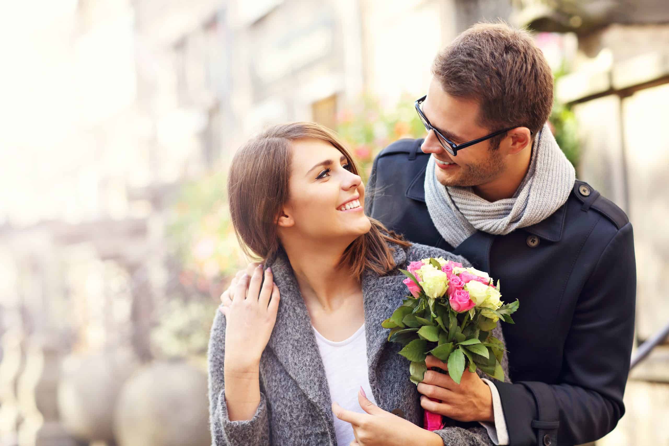 Парень заботится о девушке. Парень дарит девушке цветы. Мужчина дарит цветы женщине. Влюбленные весной. Мужчина и женщина с цветами.